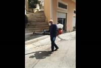 بالصورة - وزير سابق يعقّم أحد شوارع بلدته منيارة